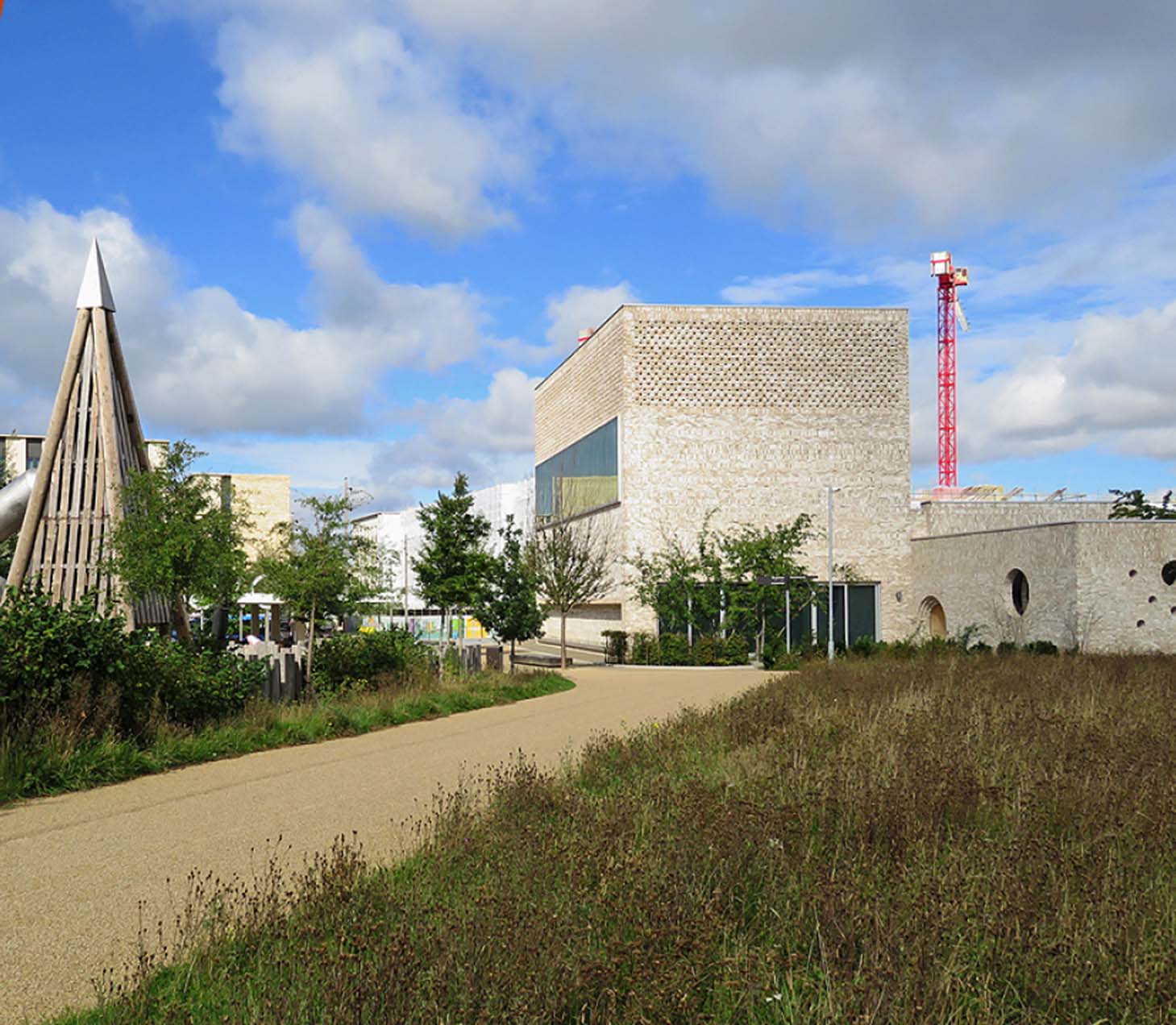 Image of a path leading through grassland leading to modern building infrastructure